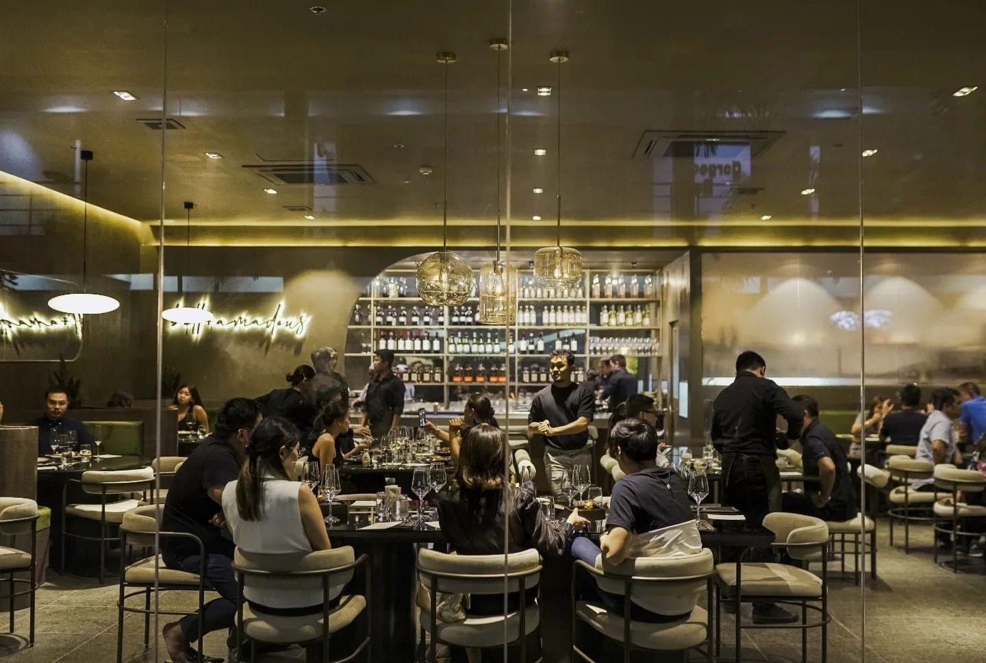 A group of people are sitting at tables in a restaurant.