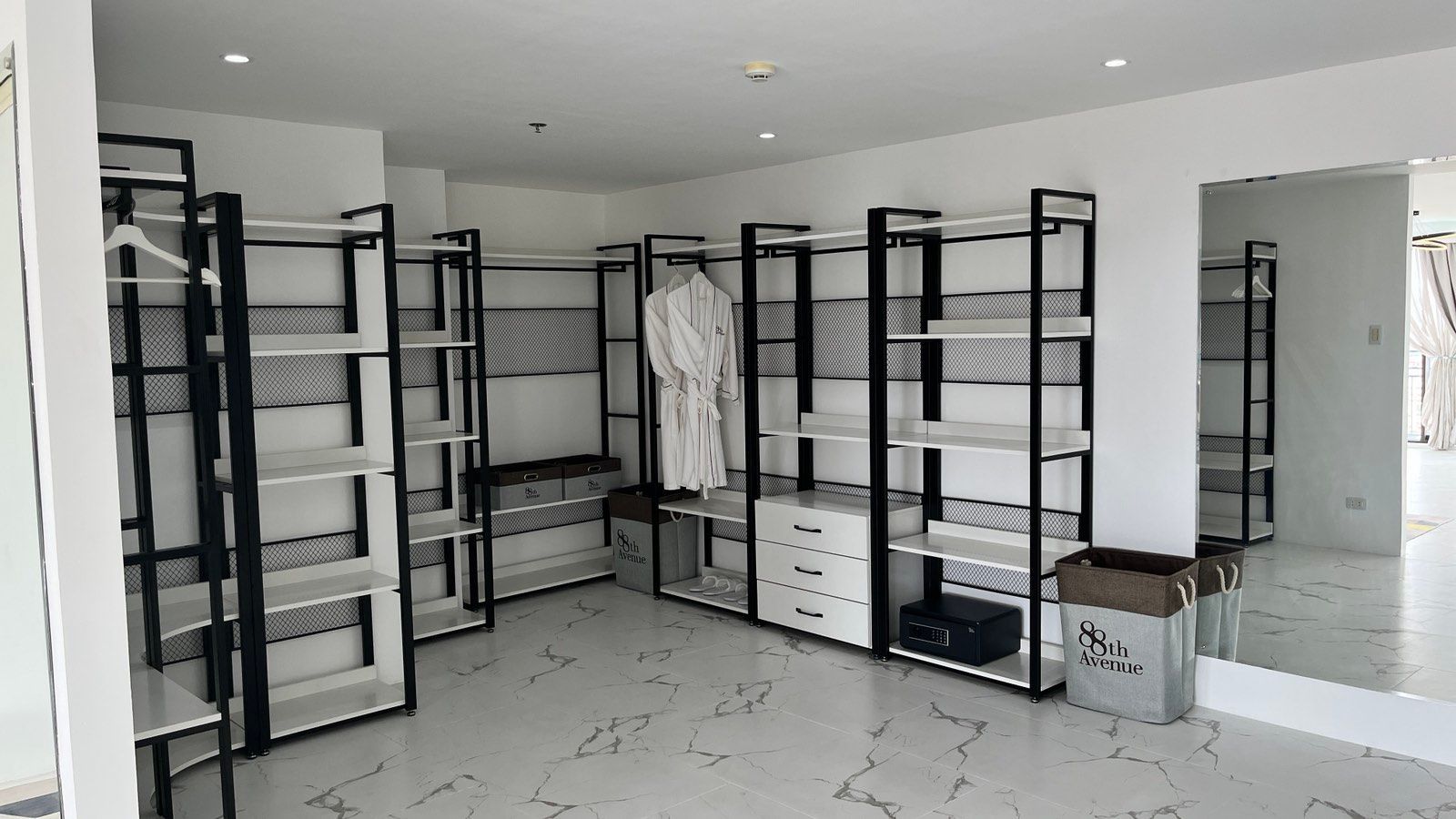 A large room with a lot of shelves and a mirror.