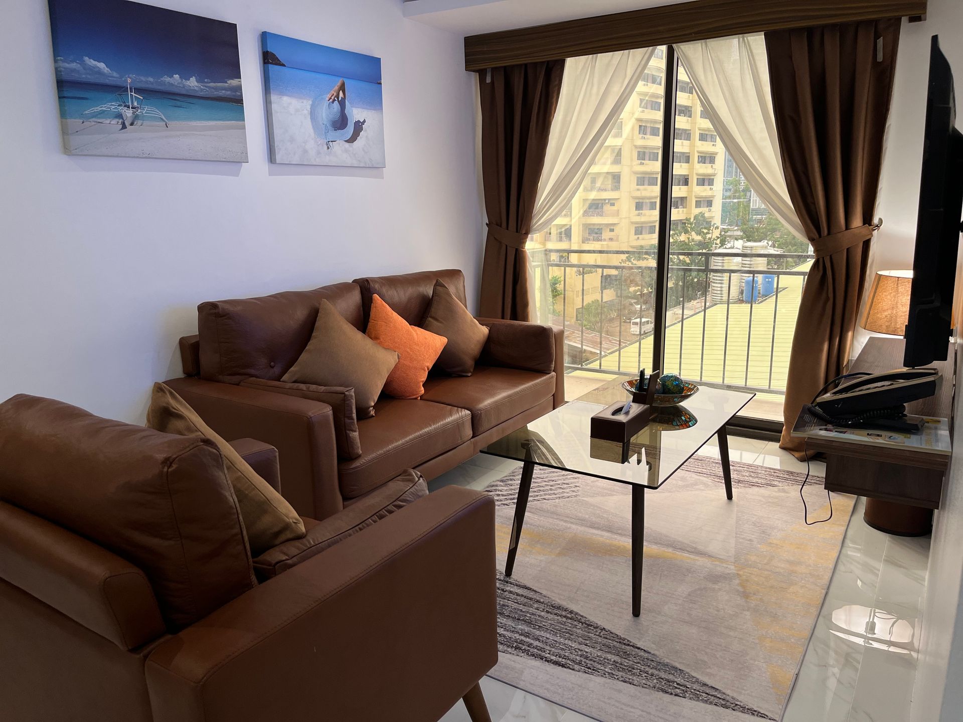 A living room with a couch , chair , coffee table and television.