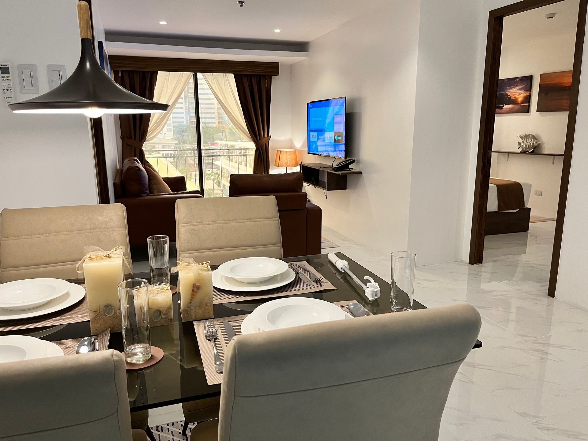 A dining room table with plates and candles on it