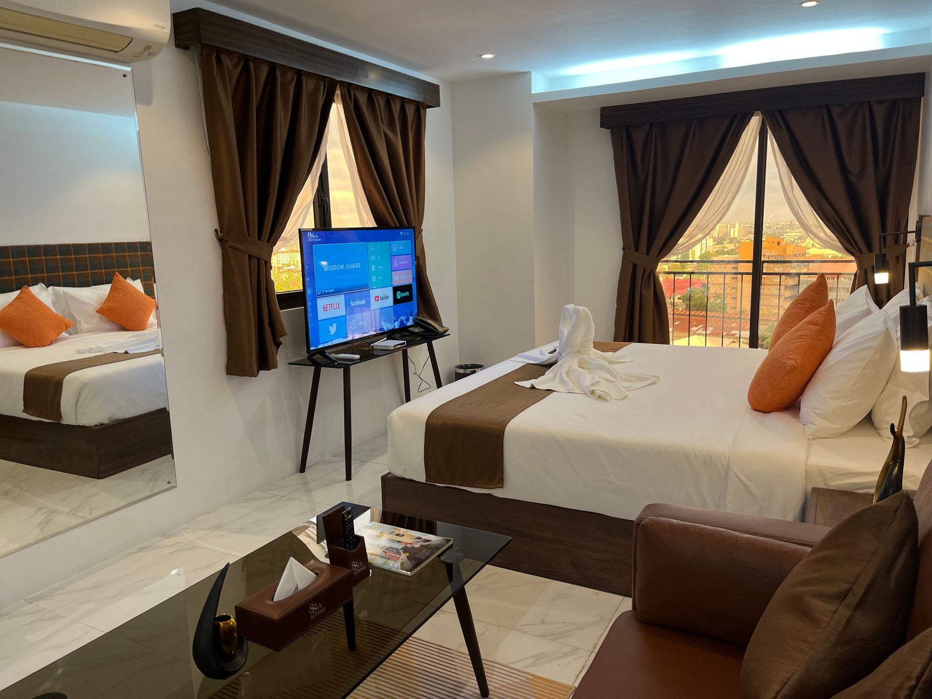 A hotel room with a king size bed and a flat screen tv.