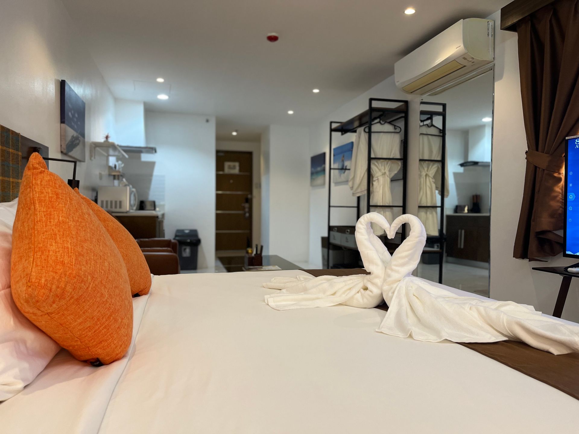 A hotel room with a large bed and a television.