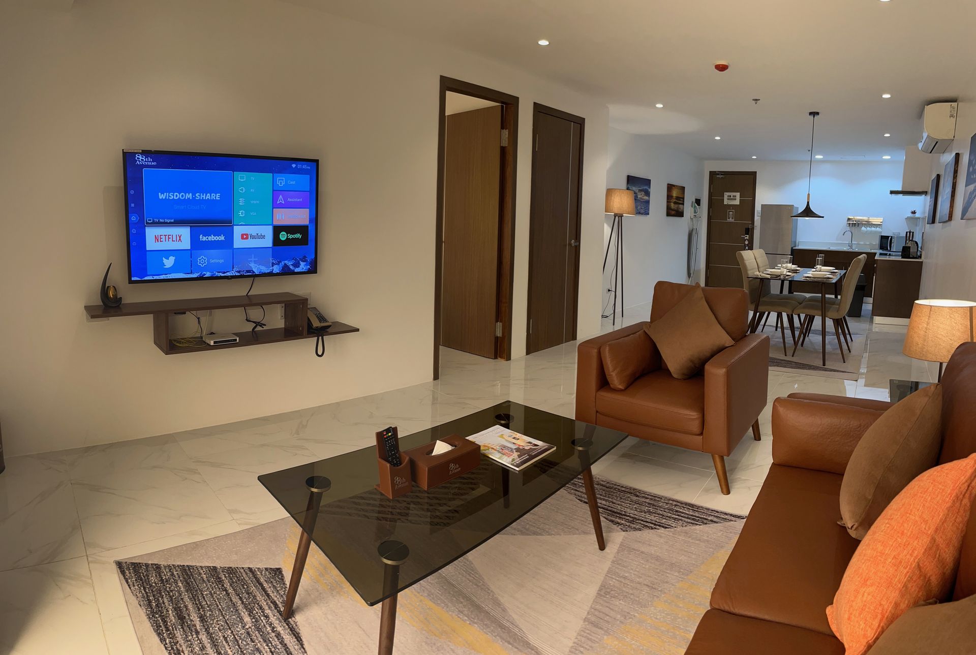 A living room with a couch , chair , coffee table and television.