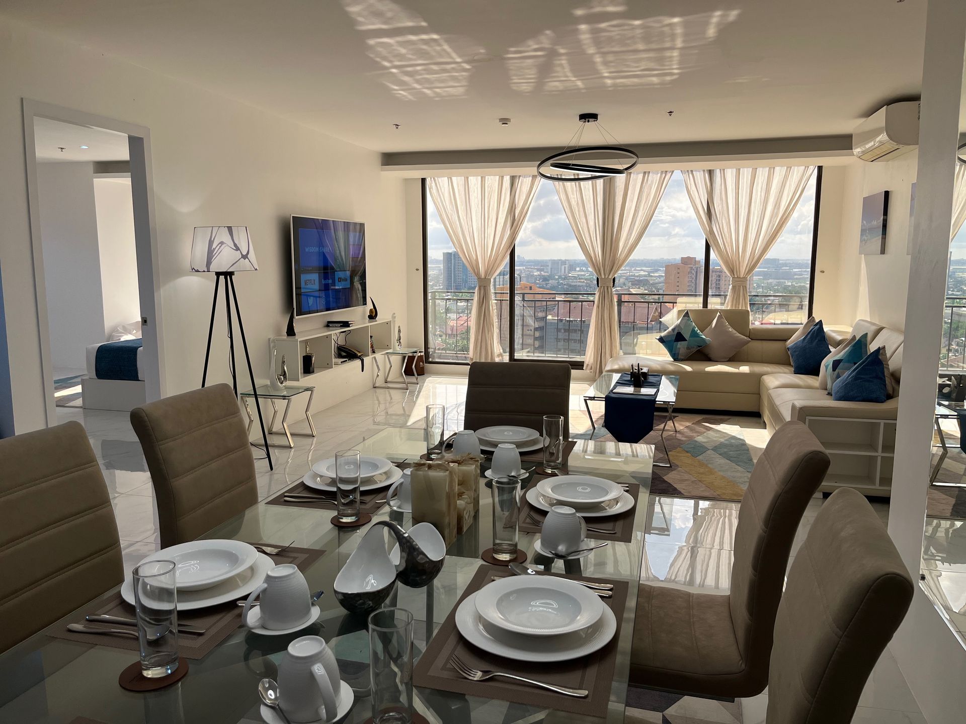 A dining room table with plates and cups on it in a living room.