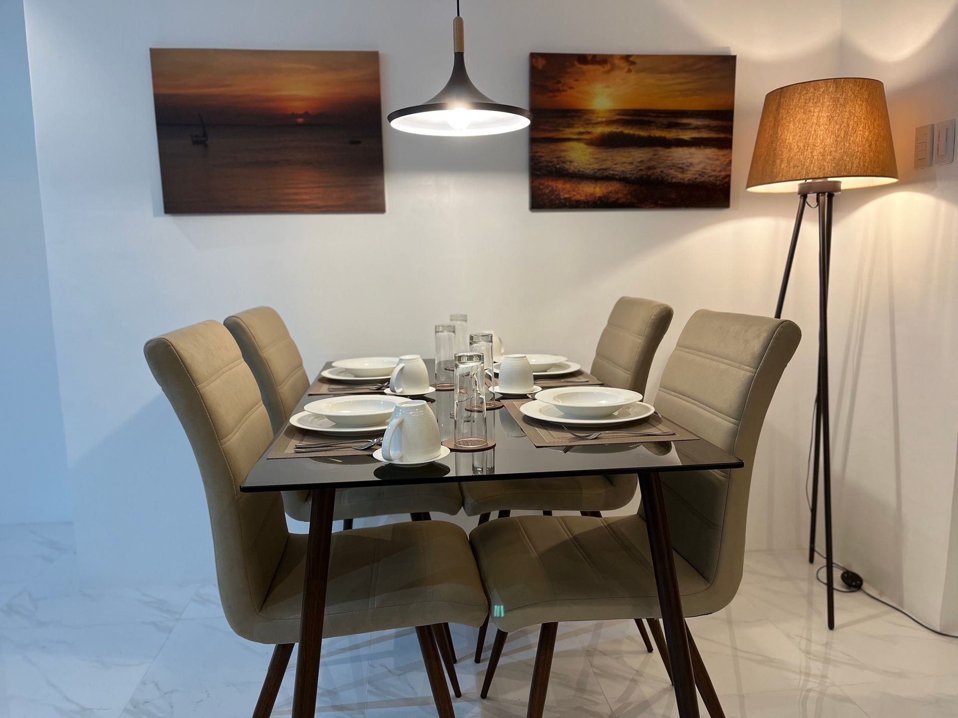 A dining room with a table and chairs and a lamp