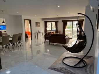 There is a hanging chair in the middle of the living room.