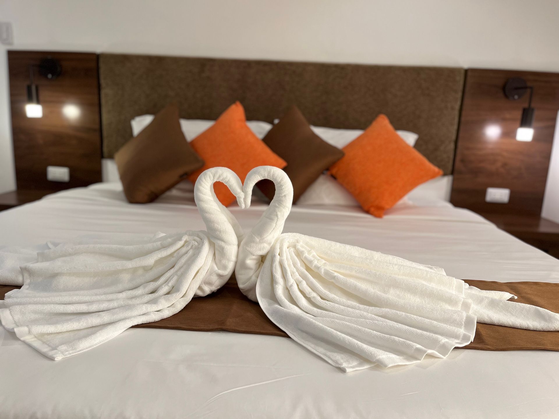 A bed with two swans made out of towels on it