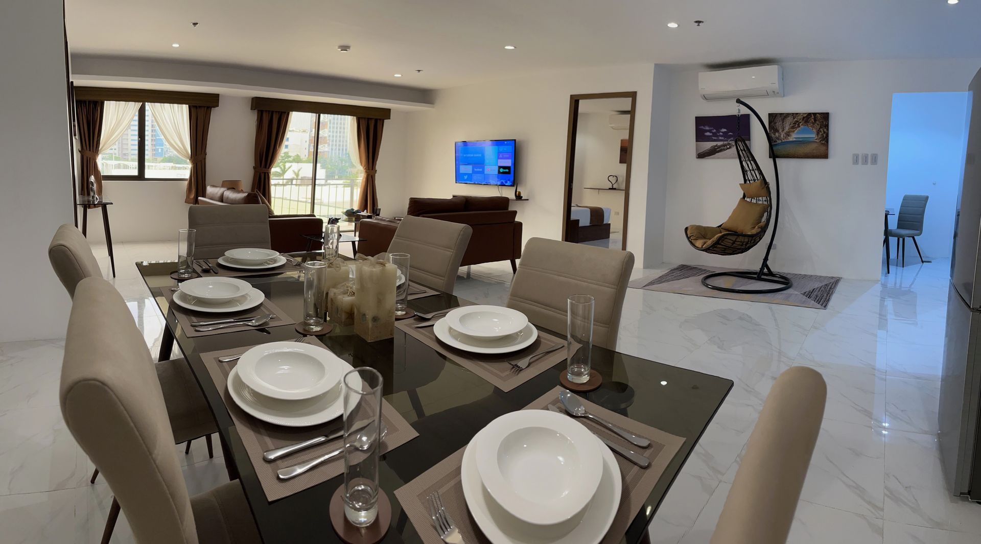 A dining room table with plates and glasses on it in a living room.