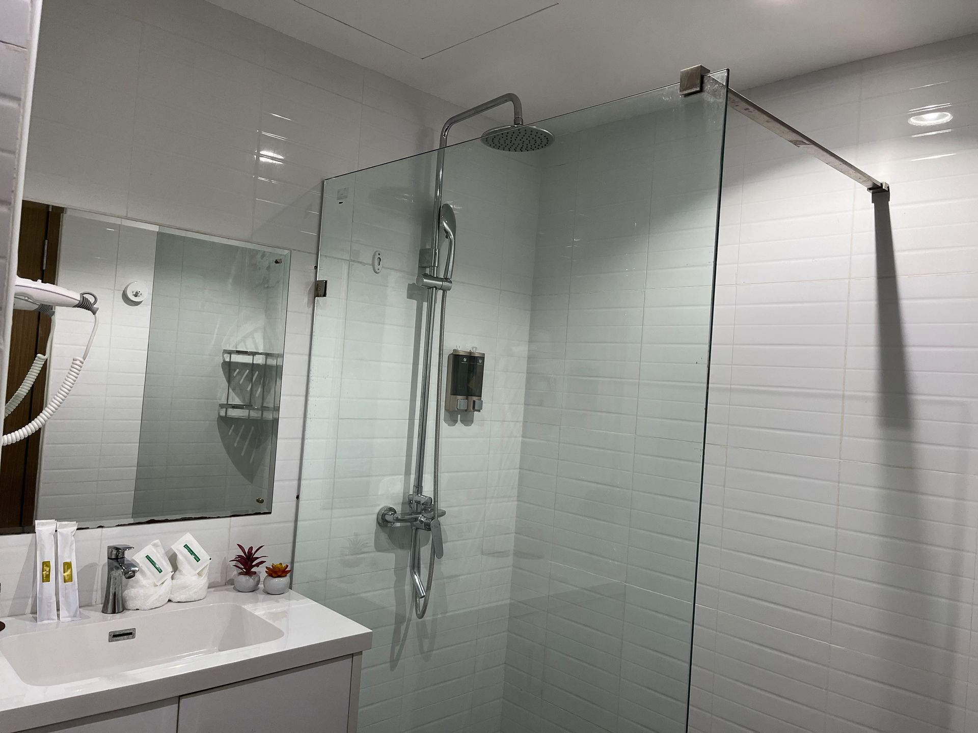 A bathroom with a sink , shower , and mirror.