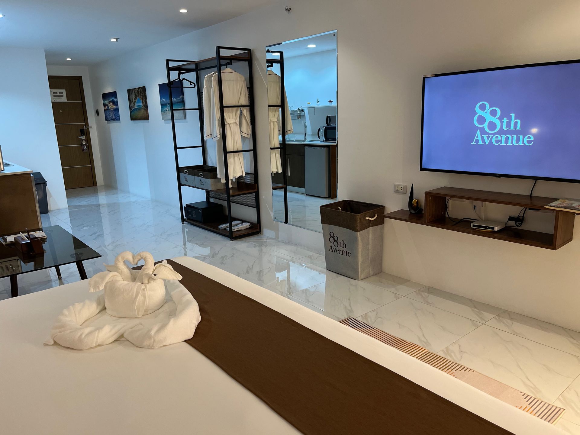 A hotel room with a large flat screen tv on the wall.