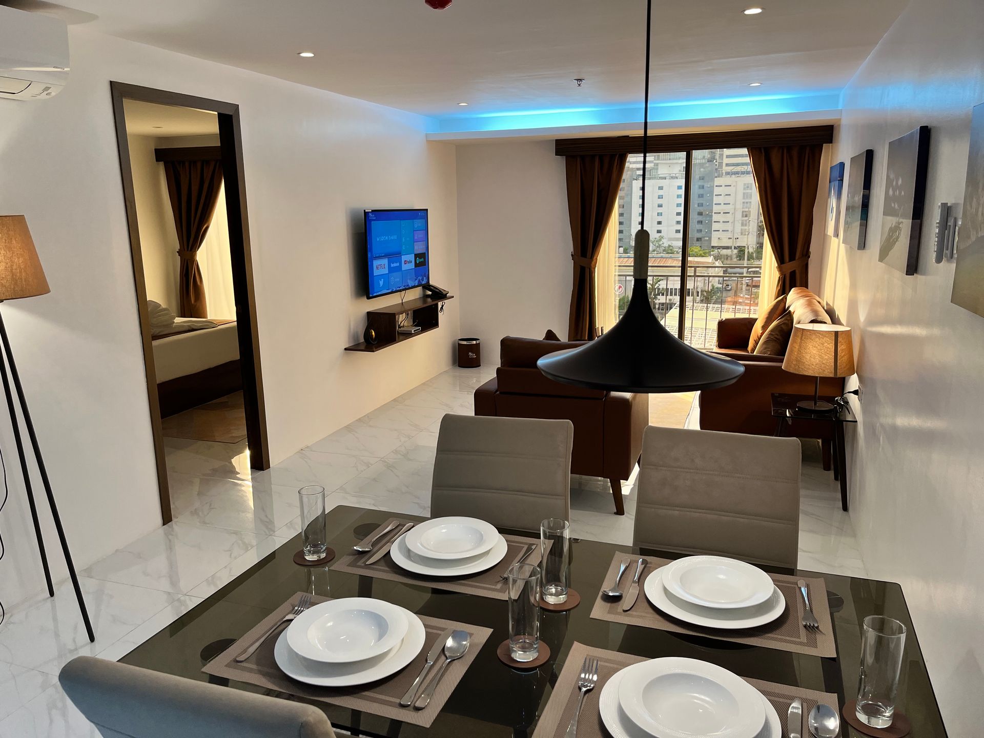 A dining room table with plates and utensils on it in a living room.