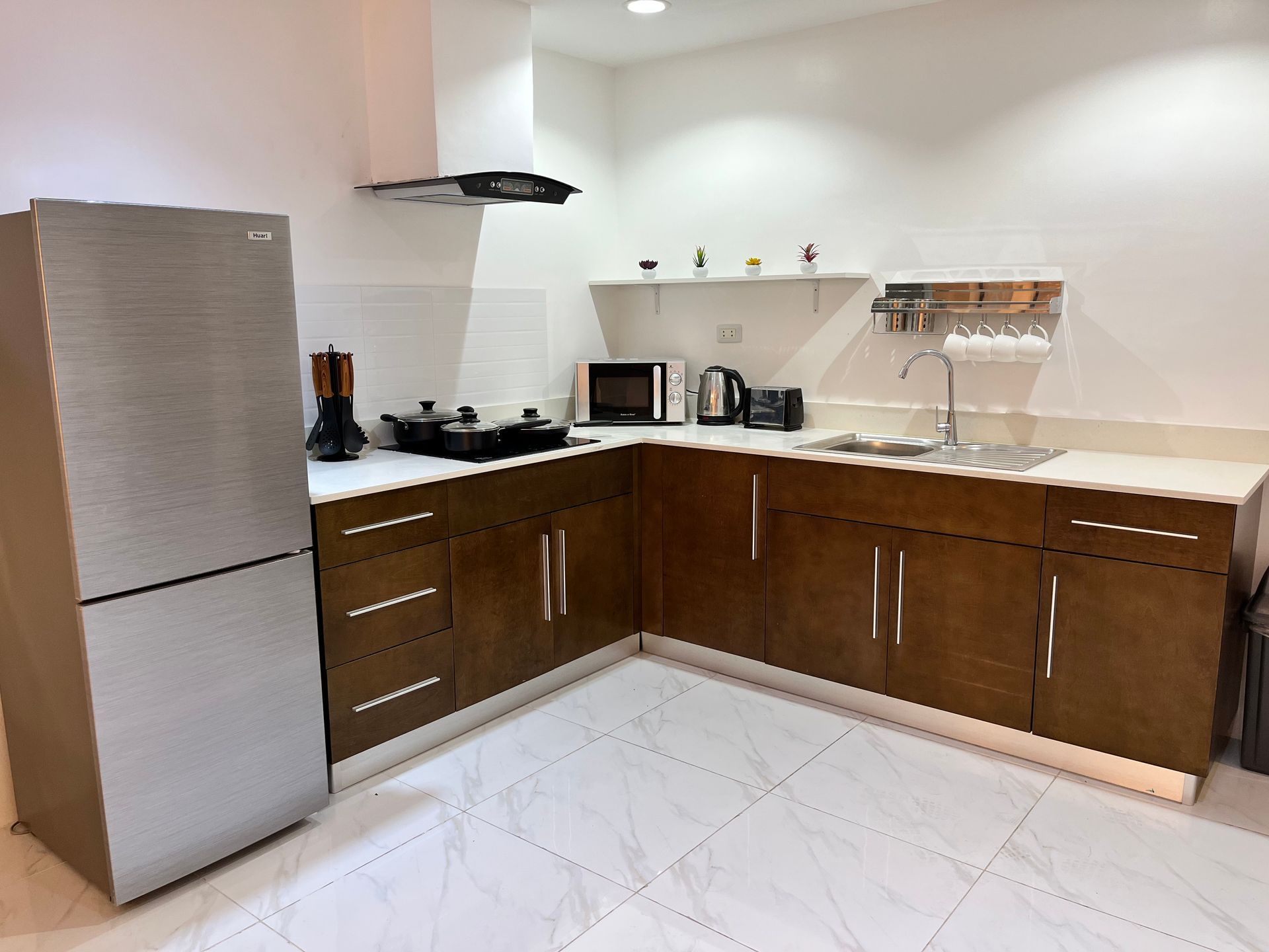 A kitchen with a stainless steel refrigerator and wooden cabinets