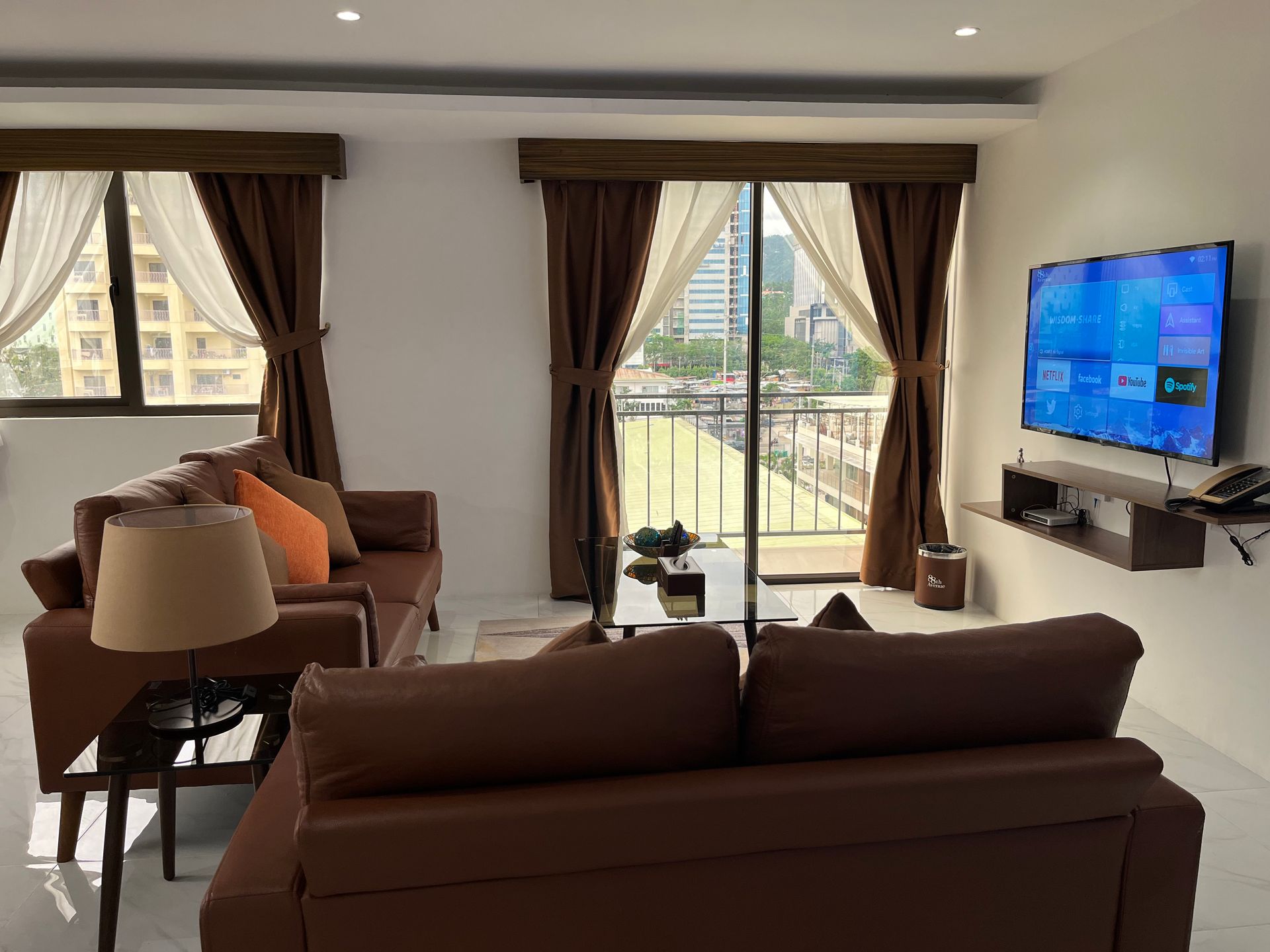 A living room with a brown couch and a flat screen tv.