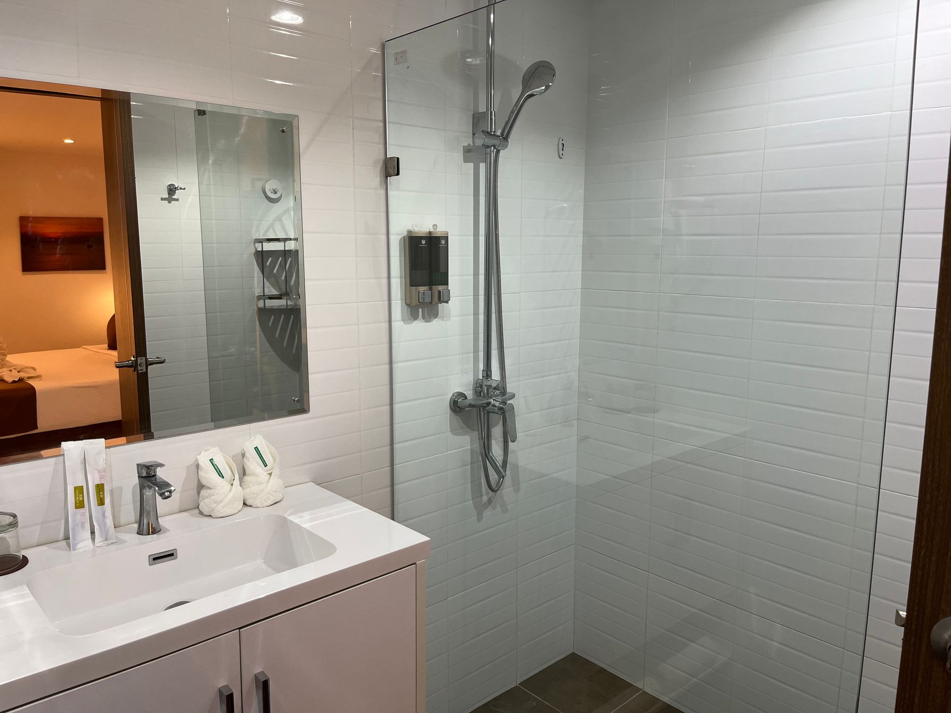 A bathroom with a sink and a walk in shower.