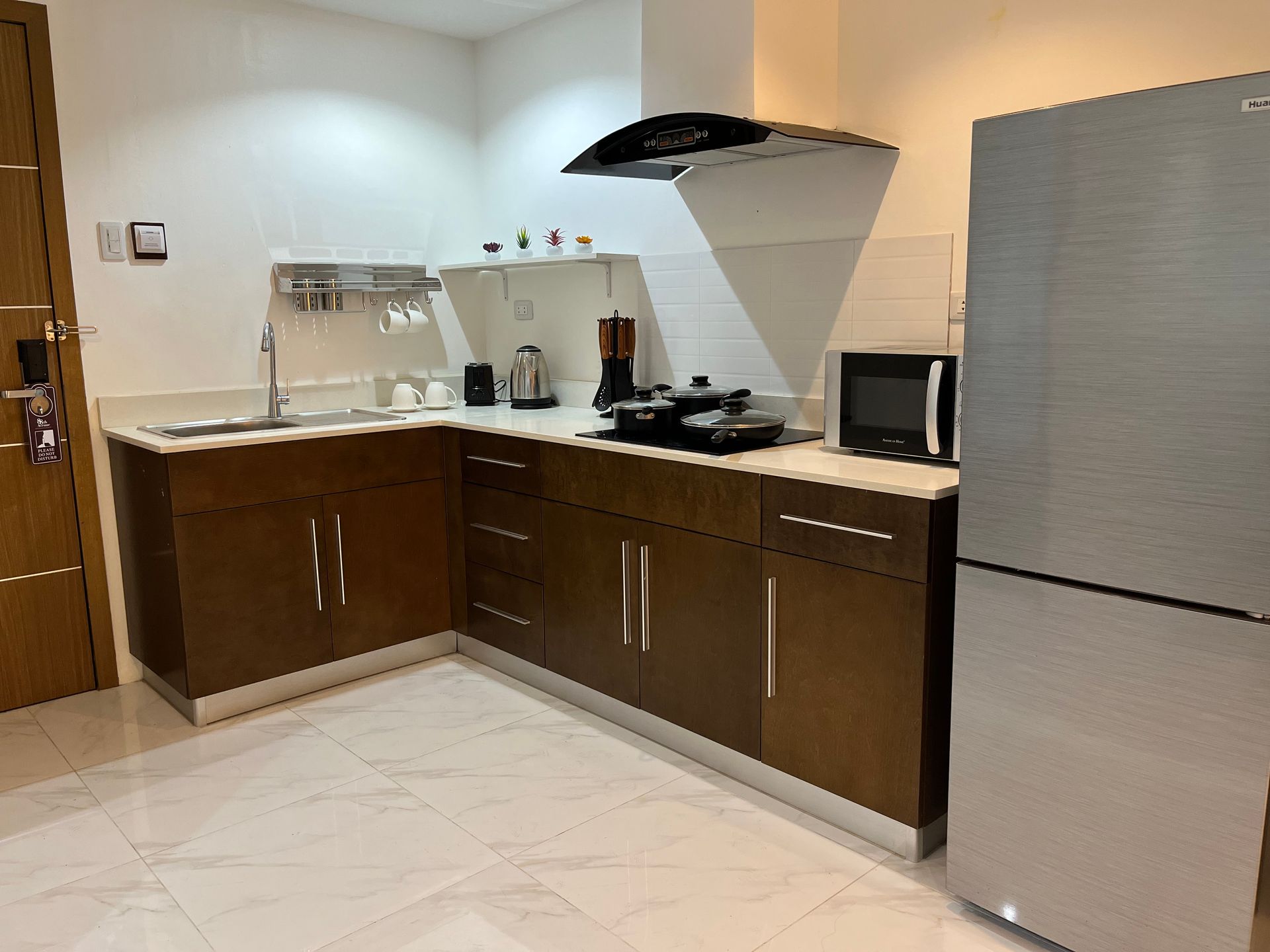 A kitchen with a sink , refrigerator , microwave and stove.