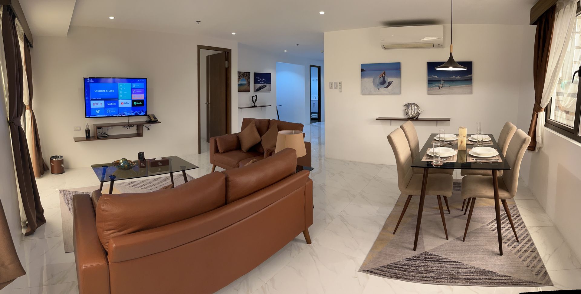 A living room with a brown couch and a dining table