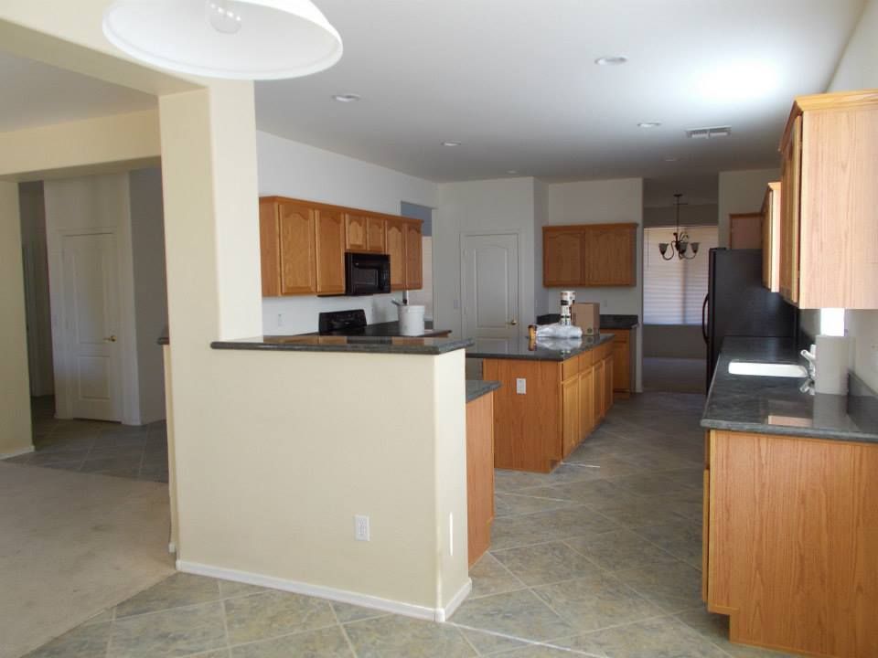 Kitchen with wood cabinets, granite countertops, and tile floor.