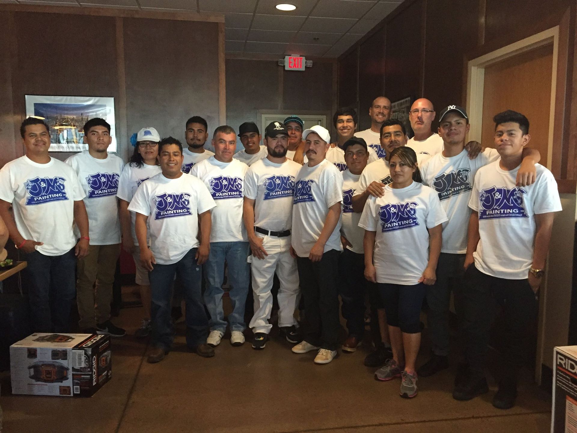 Group of workers in white shirts posing together indoors.