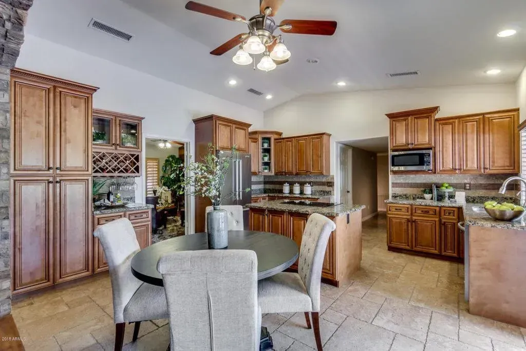 Spacious kitchen with wood cabinets, granite counters, and a round dining table with four chairs.