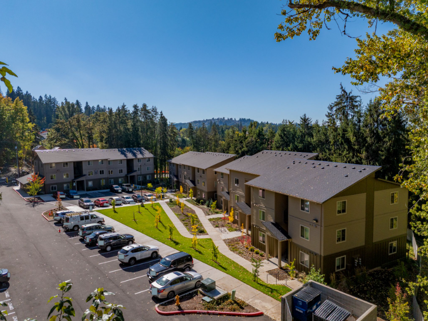 Harmona Heights Apartment community – exterior aerial view of all apartment buildings with parking lot and grassy area.