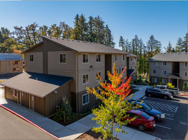 Harmona Heights Apartment community – exterior of leasing office and apartment community with parking.