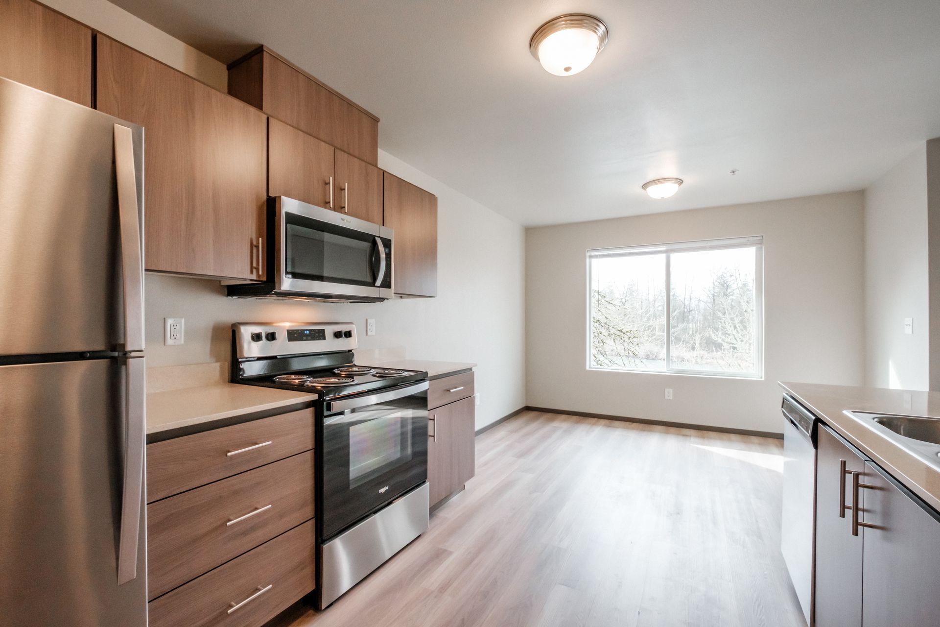 Jefferson Terrace Apartments in Jefferson Oregon – kitchen, refrigerator, microwave, stove, wooden cabinetry.