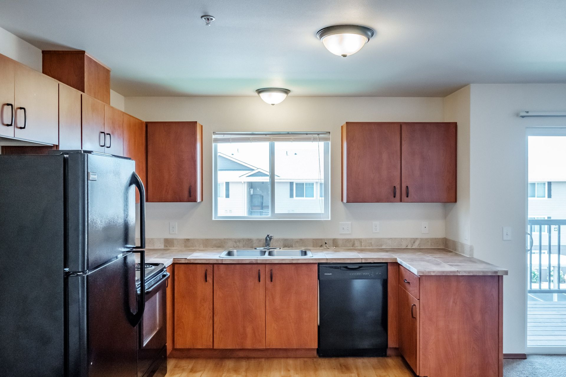 Newcastle Place Apartments in Salem, OR Near Chemeketa Community College, two-bedroom, two-bath – kitchen and window view.