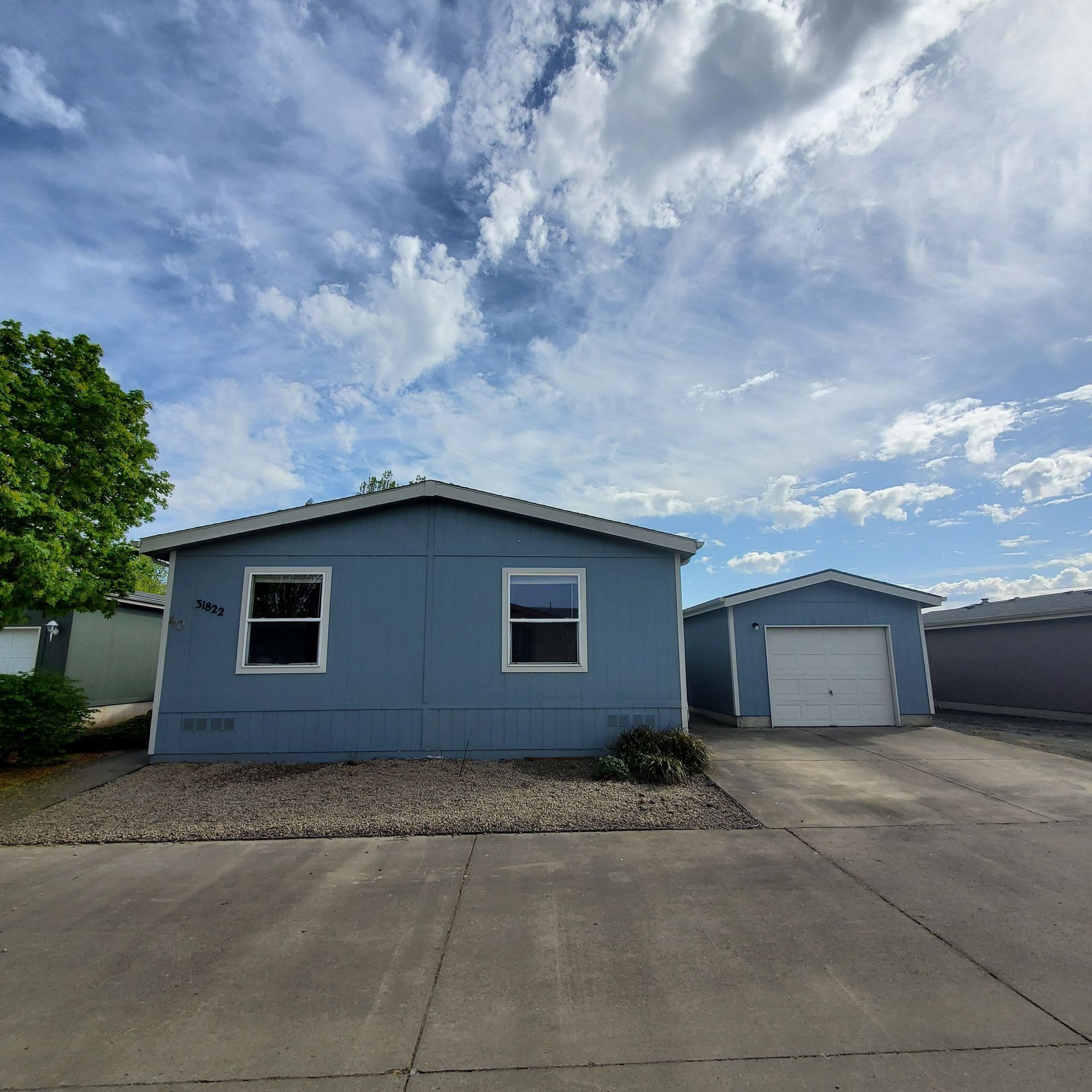 Ashwood Estates mobile homes in Tangent Oregon –blue manufactured home exterior front and garage.