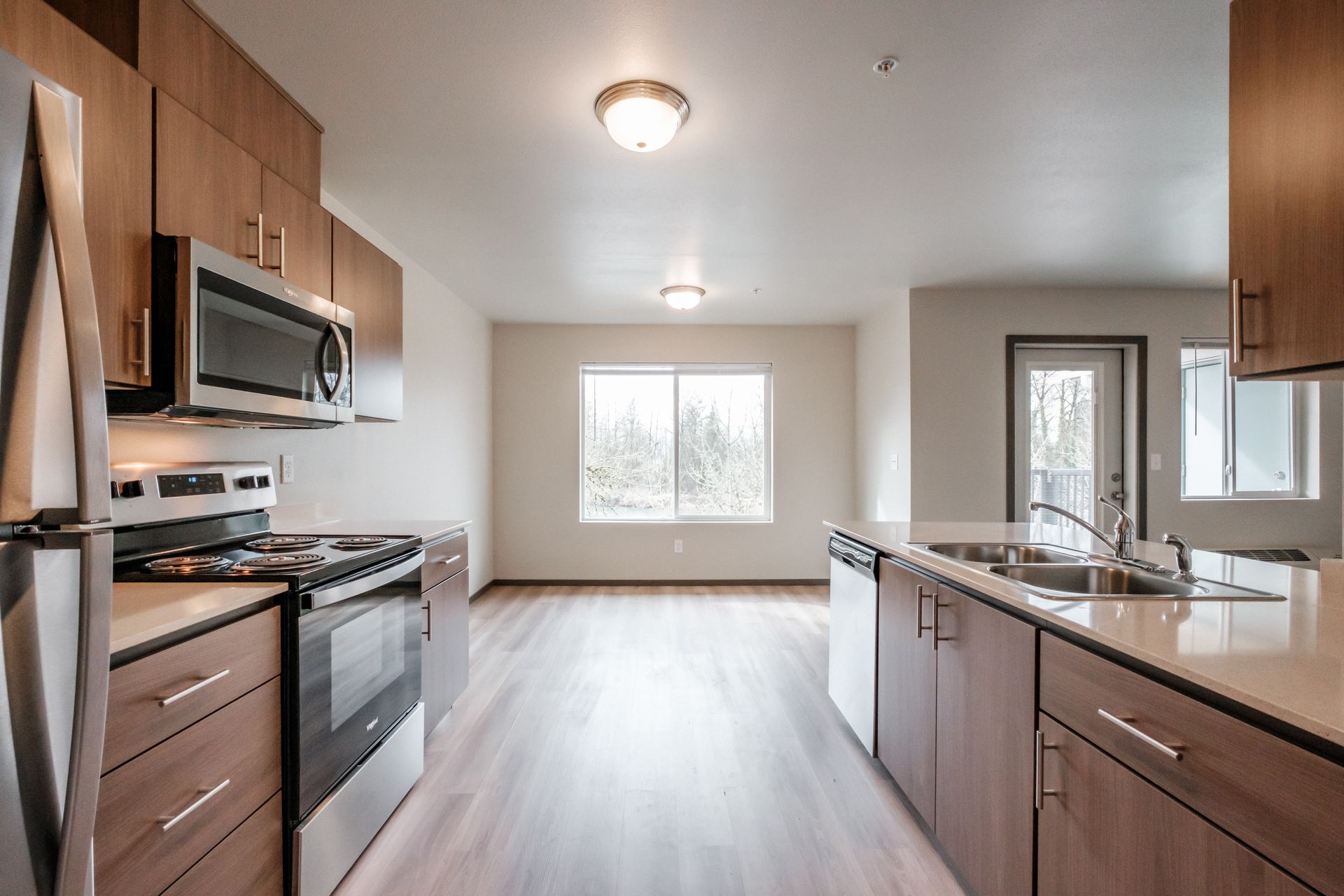 Jefferson Terrace Apartments in Jefferson Oregon – kitchen, dishwasher, microwave, stove, wooden cabinetry.