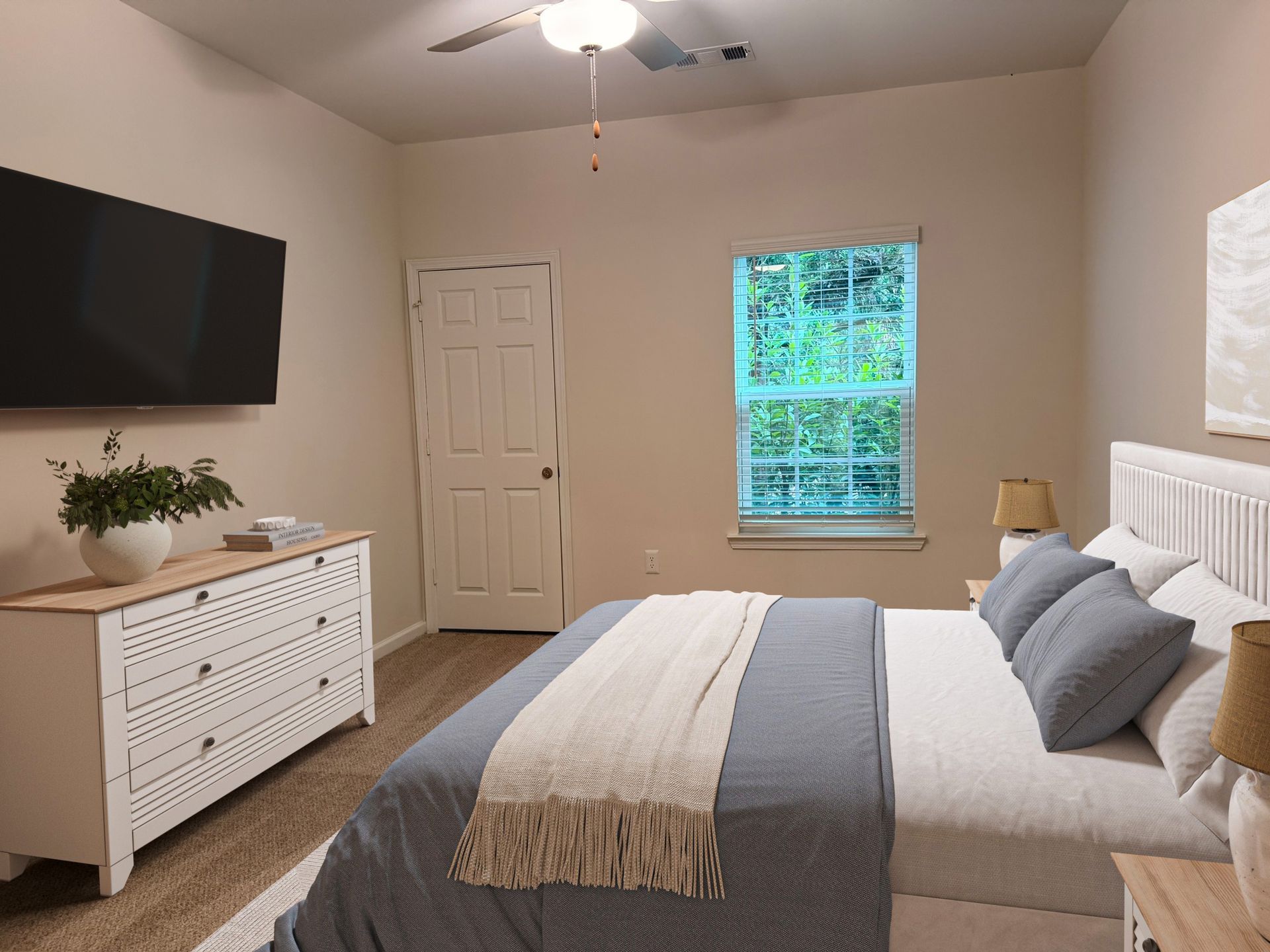 Bedroom in an apartment with a bed, dresser, wall-mounted TV, ceiling fan, and a window.