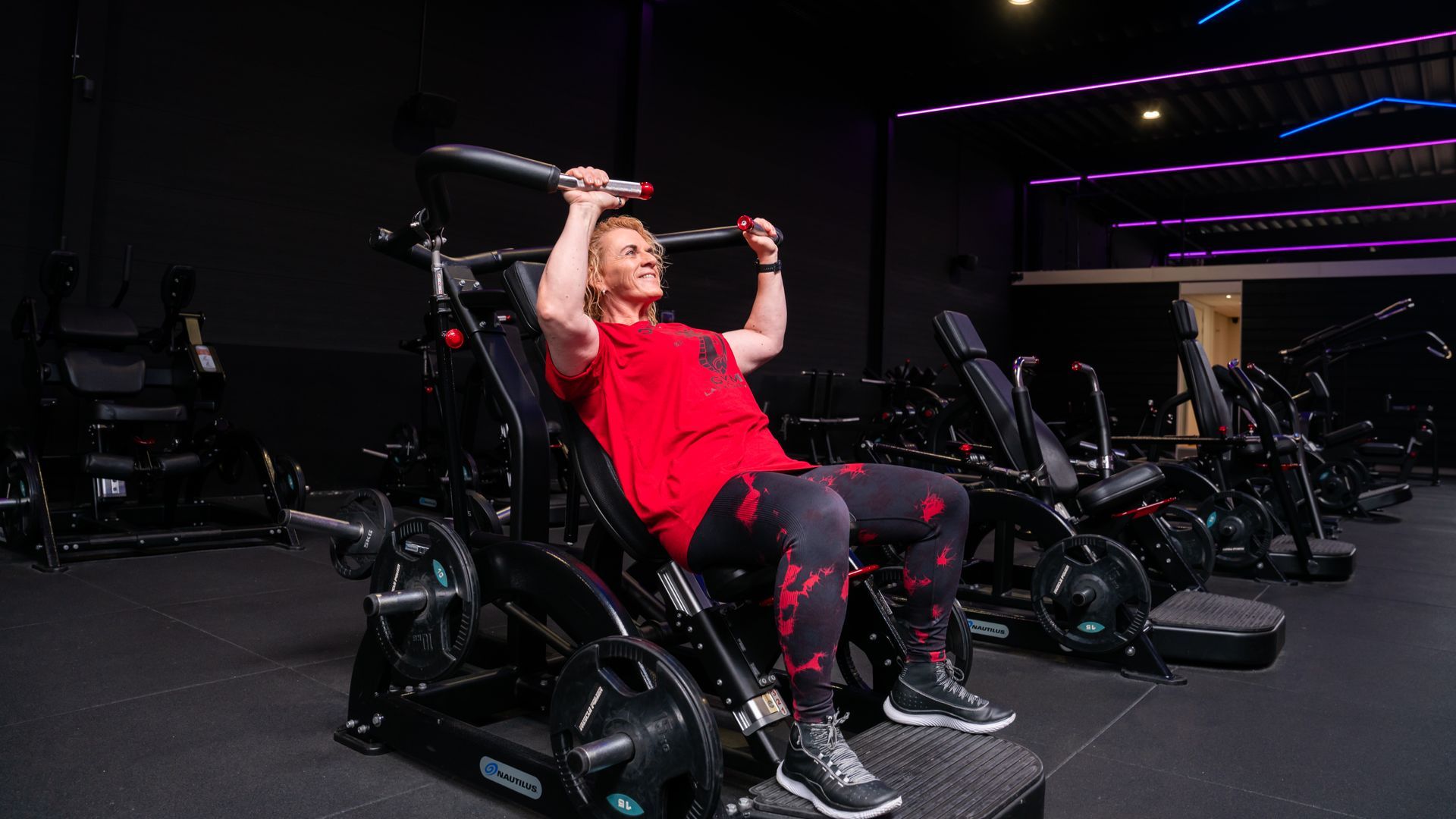 Man doet push-ups op een groen grasveld, onder begeleiding van een personal trainer in de sportschool.