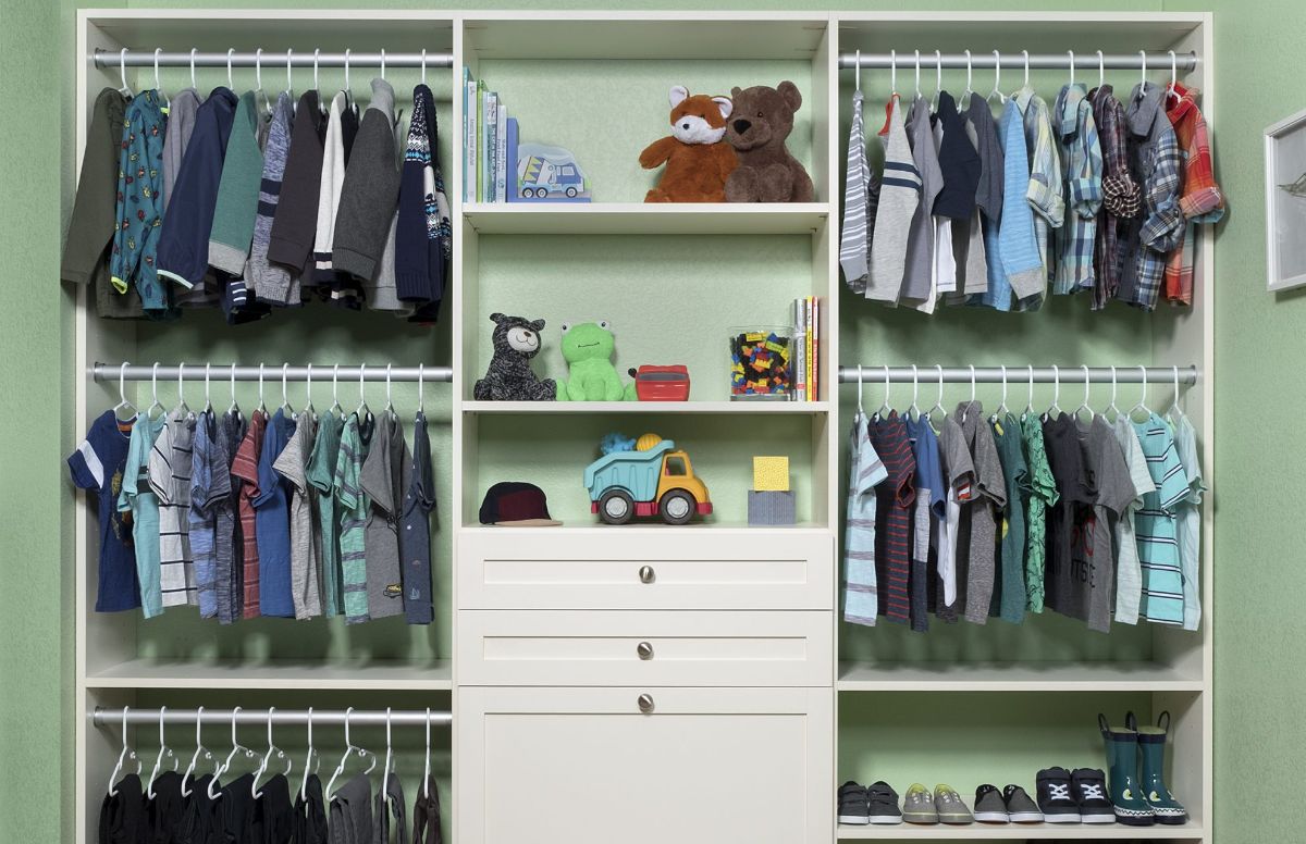 A child 's closet filled with clothes and toys.