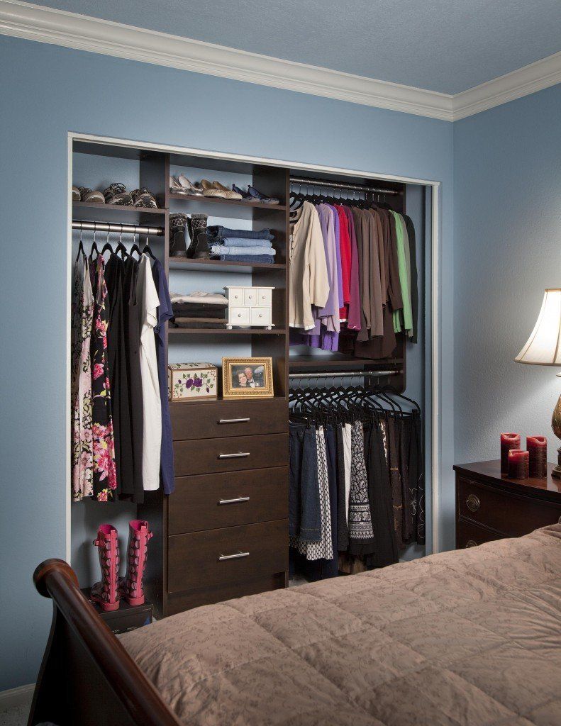 A bedroom with a reach-in closet and a bed