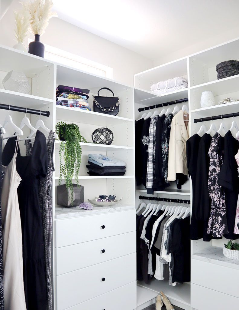 A walk in closet filled with clothes and a dresser.