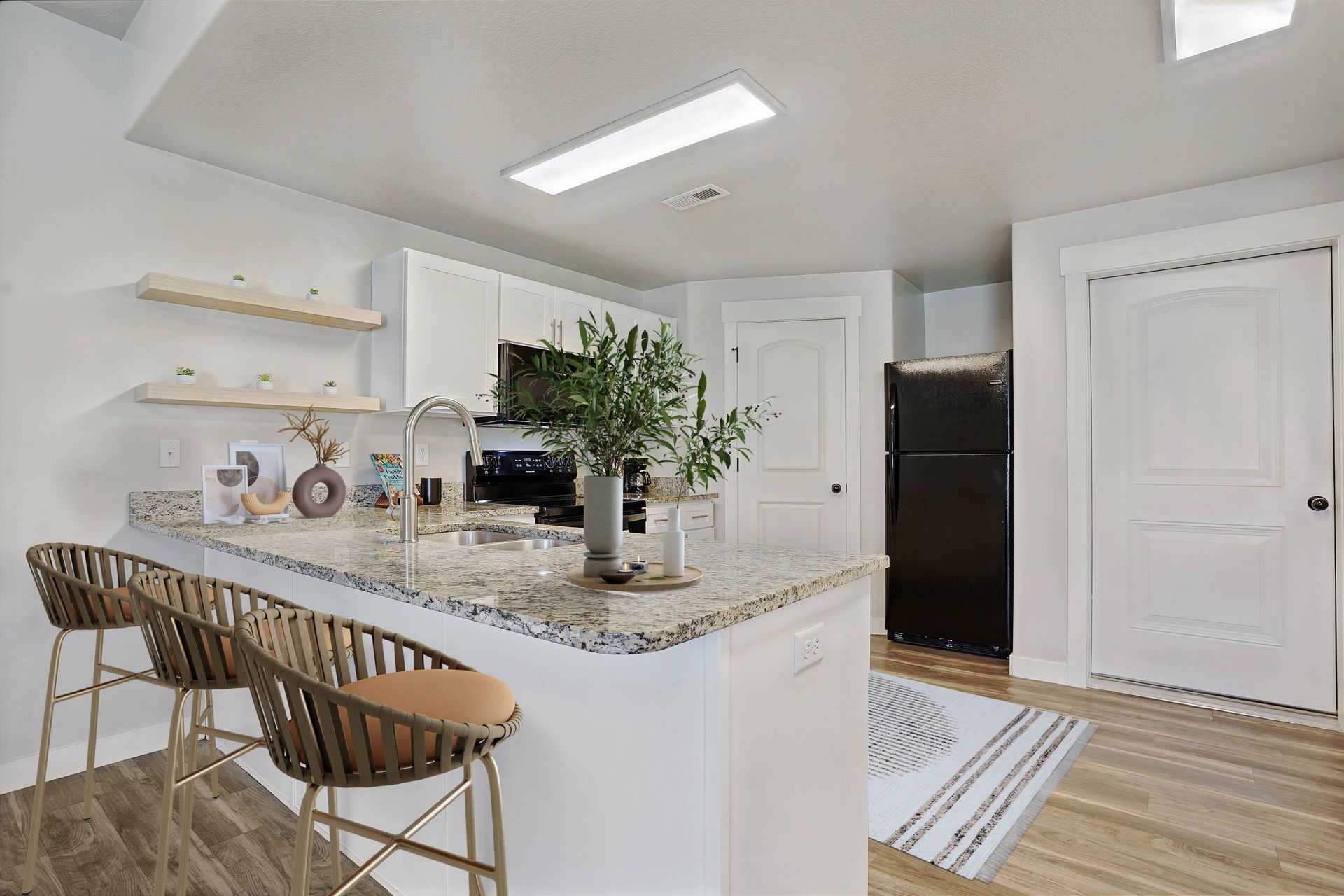 Model apartment kitchen with dining bar.