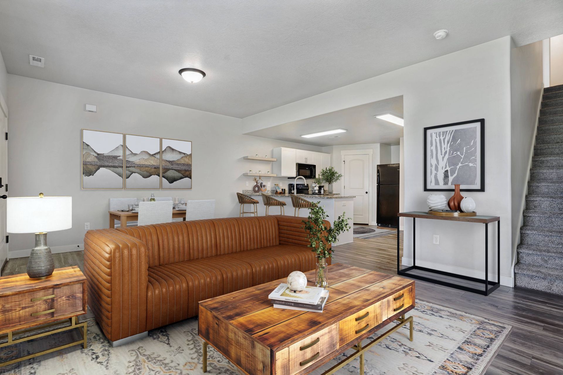 Living room with leather sofa, wooden coffee table, and open kitchen.