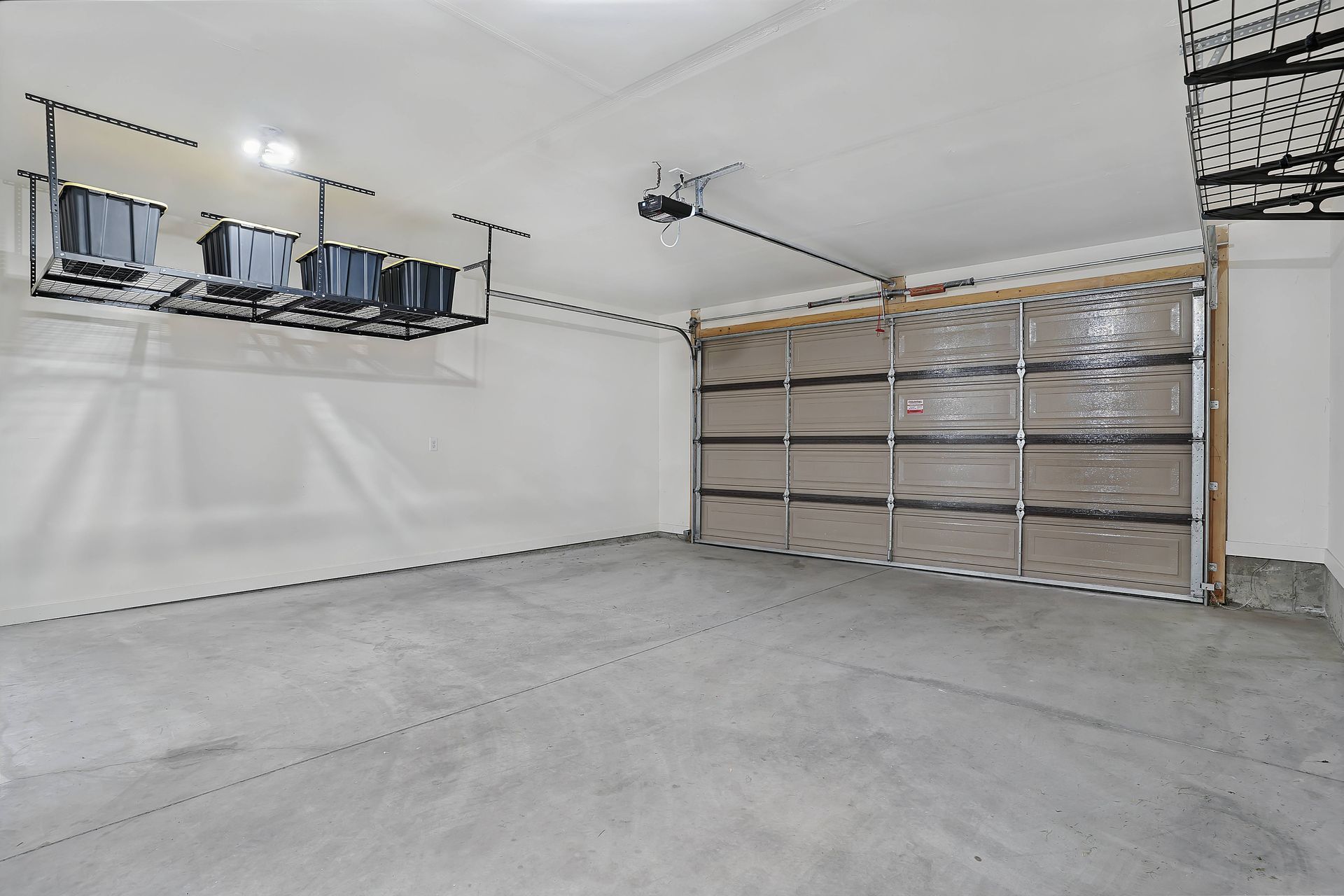Empty garage with a concrete floor and a clear, glass-paneled garage door.