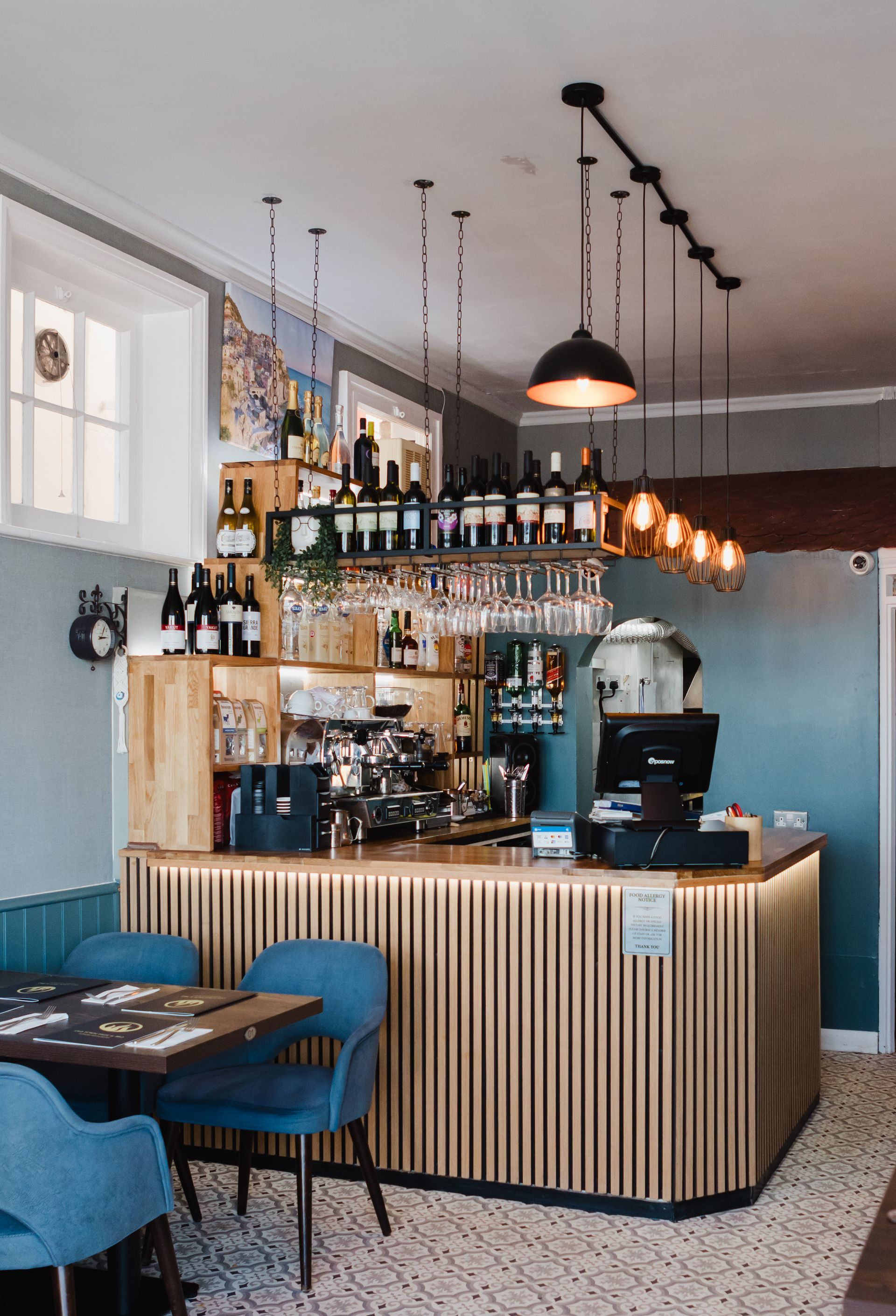 A restaurant with a bar and tables and chairs