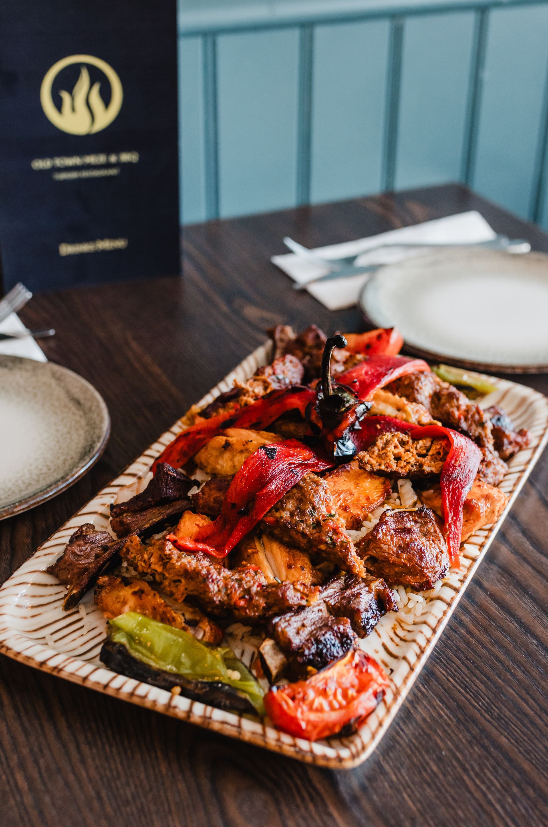 A plate of food on a table with a menu in the background