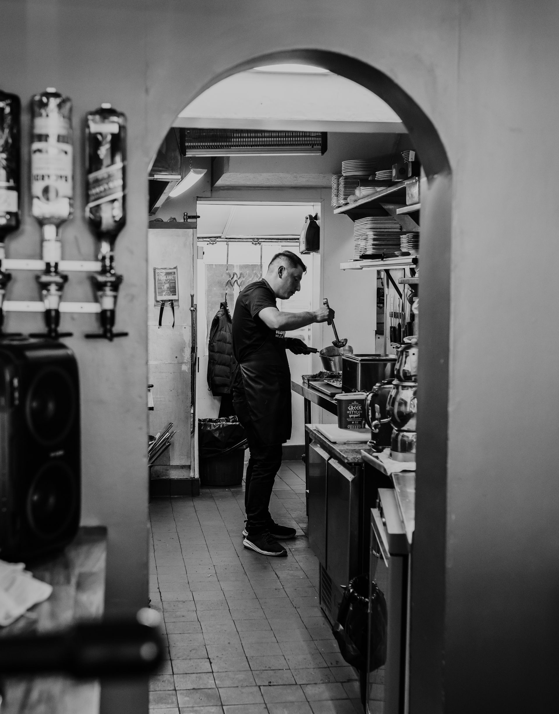 A black and white photo of a man in a kitchen