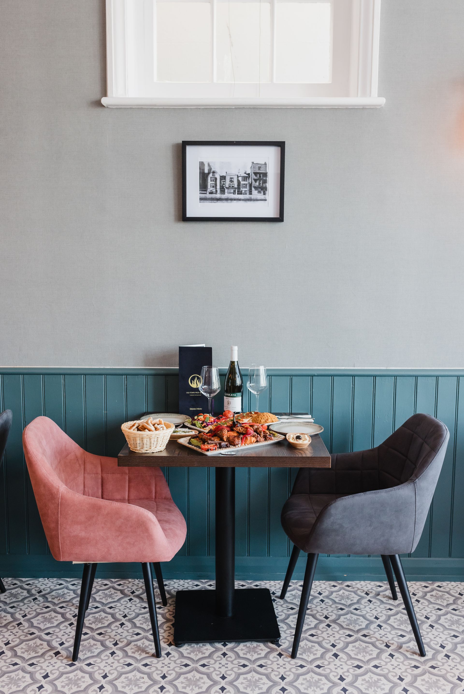 A table in a restaurant with a picture on the wall above it