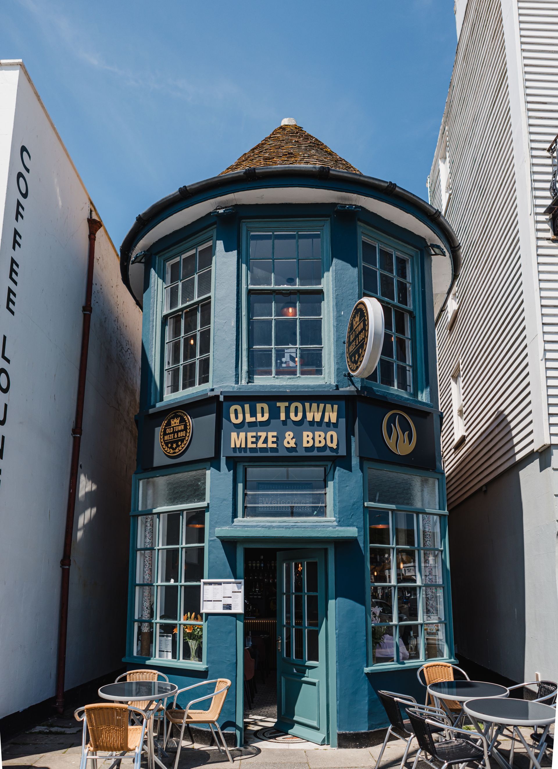 A blue building with a sign that says old town meze & pub