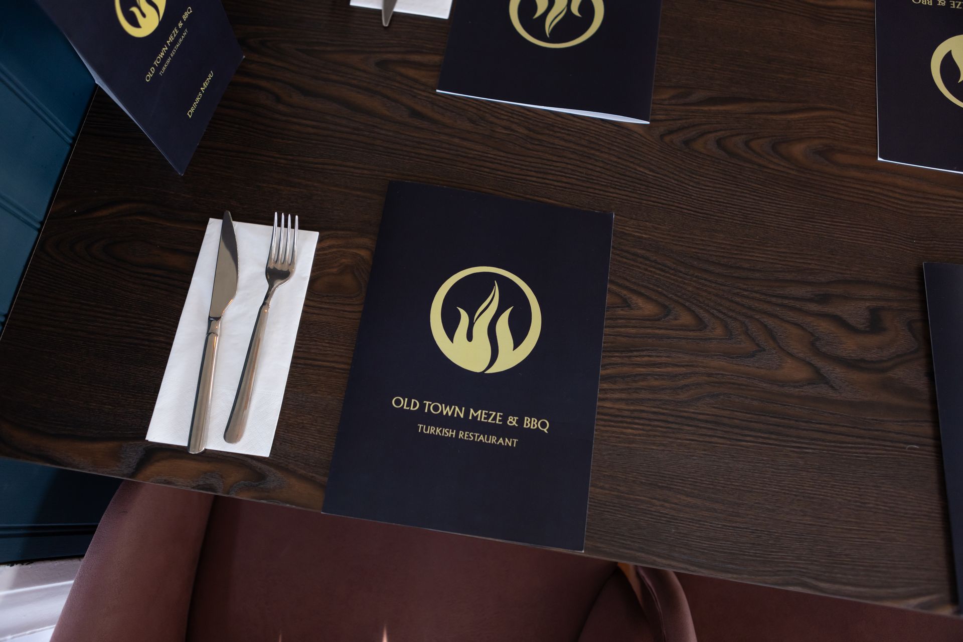 A place setting for a restaurant with a menu on the table