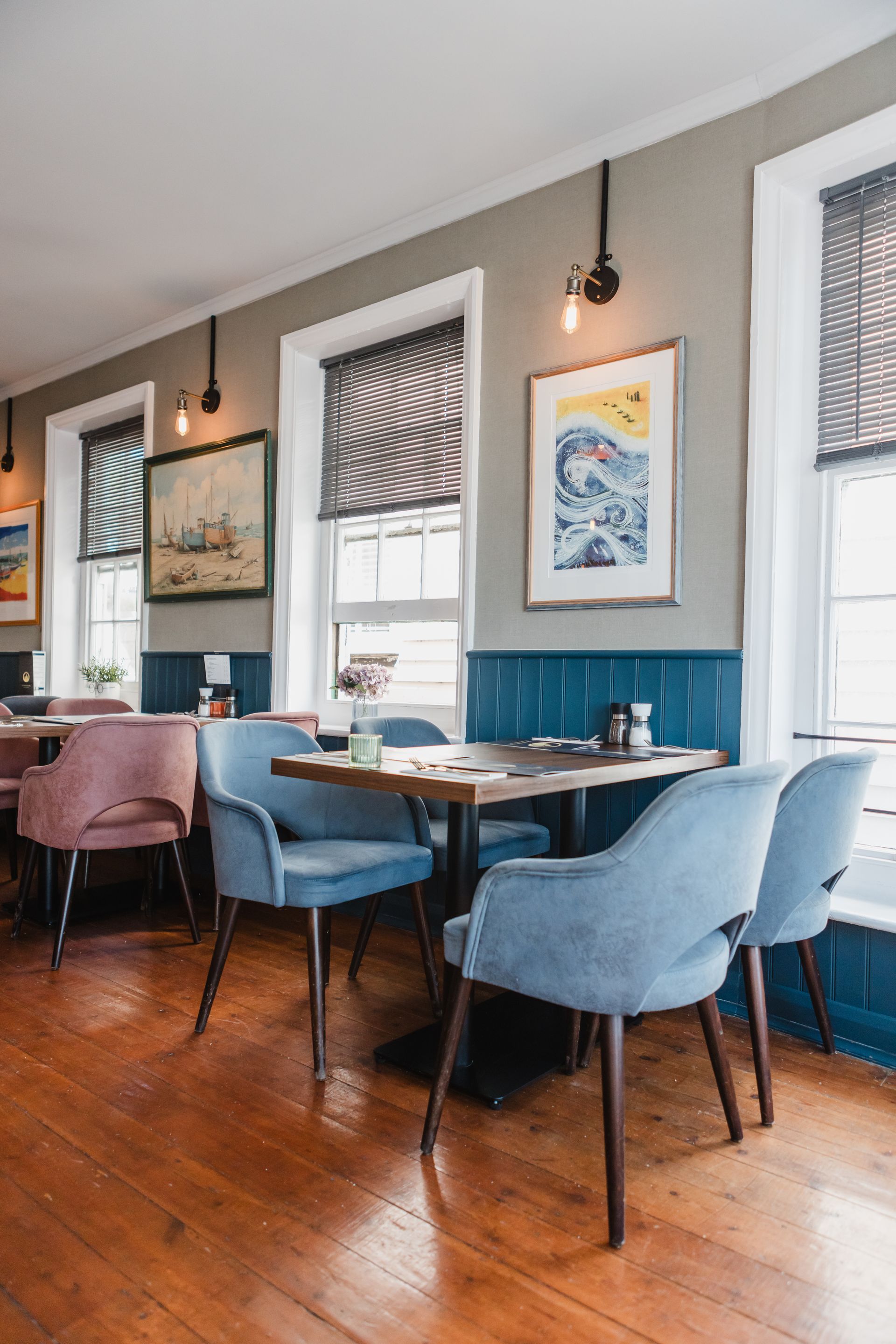 A restaurant with tables and chairs and a wooden floor