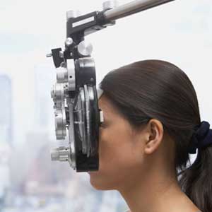 Profile of Asian woman's face behind ophthalmology equipment