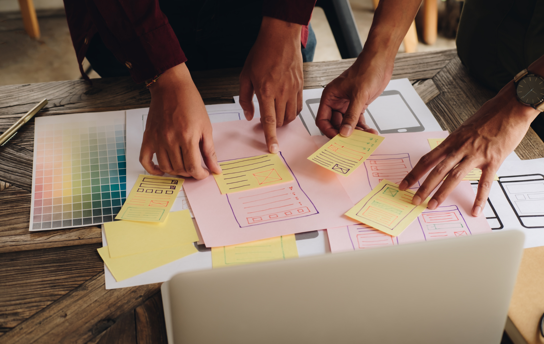 A group of people are sitting at a table working on a project.
