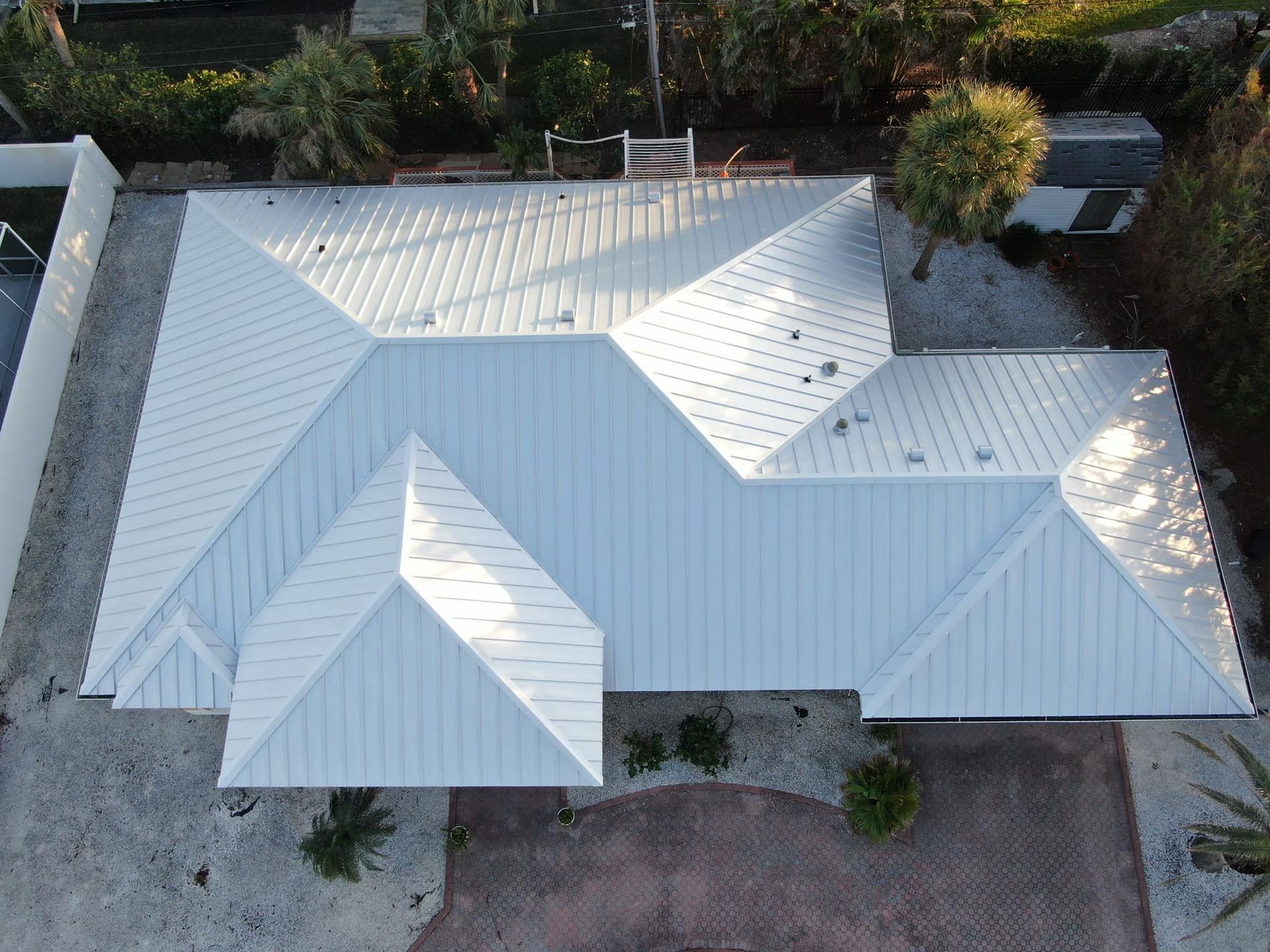 An aerial view of a house with a white roof