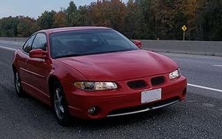 Red car on road - Insurance agency in Stoughton, MA