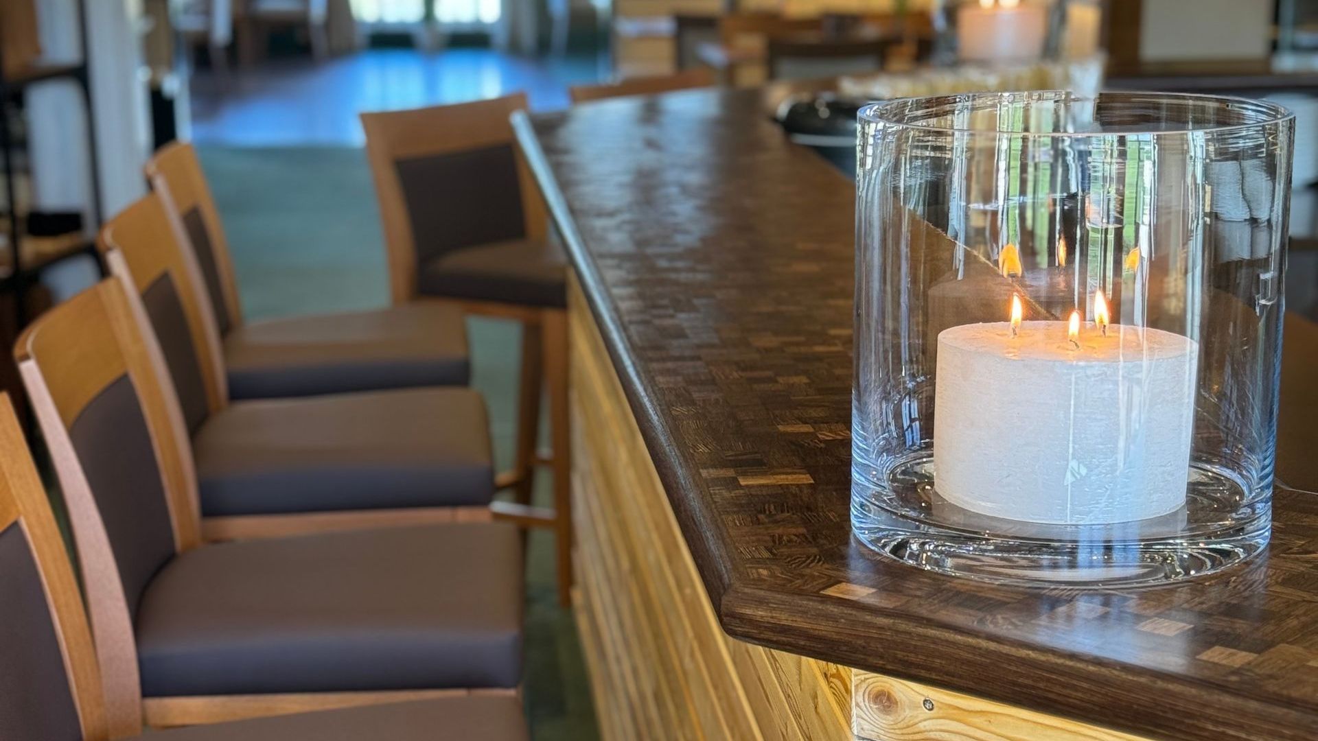 eine Bar mit einer Kerze in einem Glas auf der Theke.