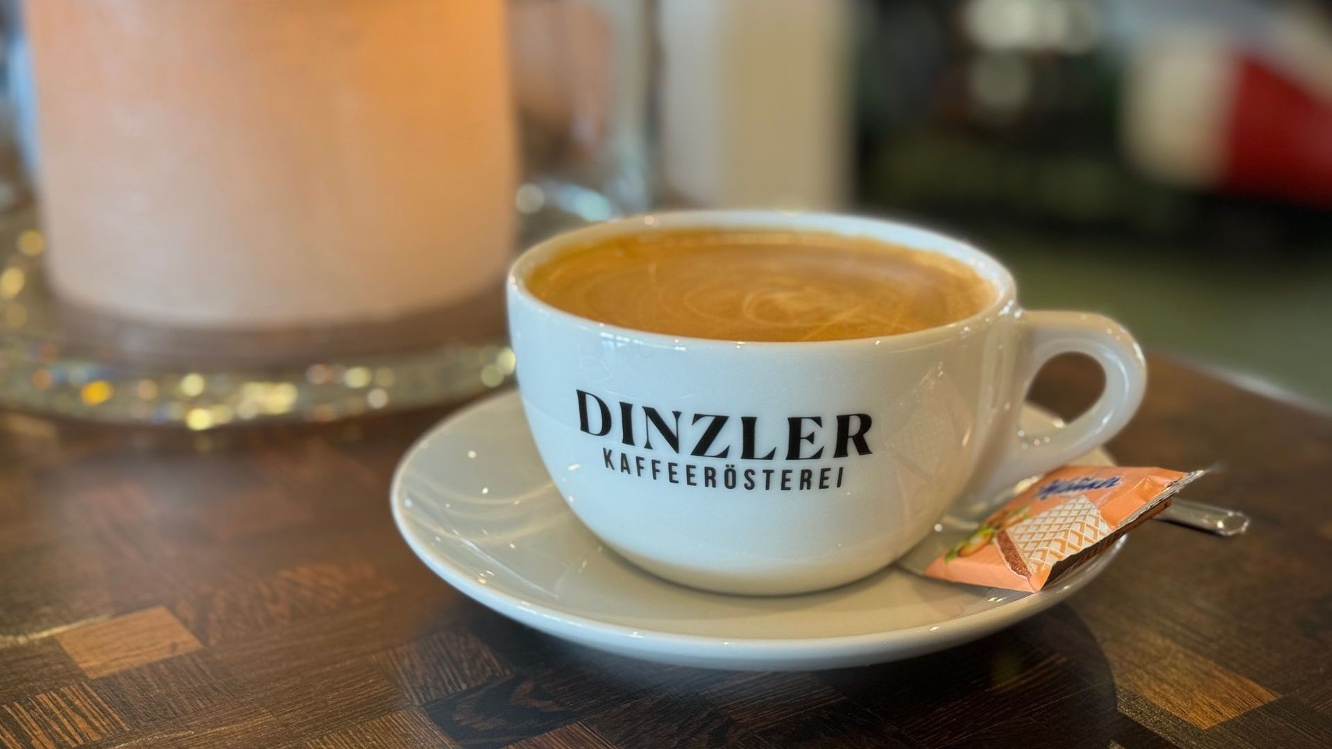 Eine Tasse Kaffee auf einem Holztisch. Auf der Tasse steht 
